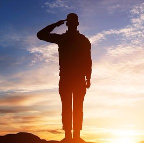 Silhouette of an American serviceman standing at salute.